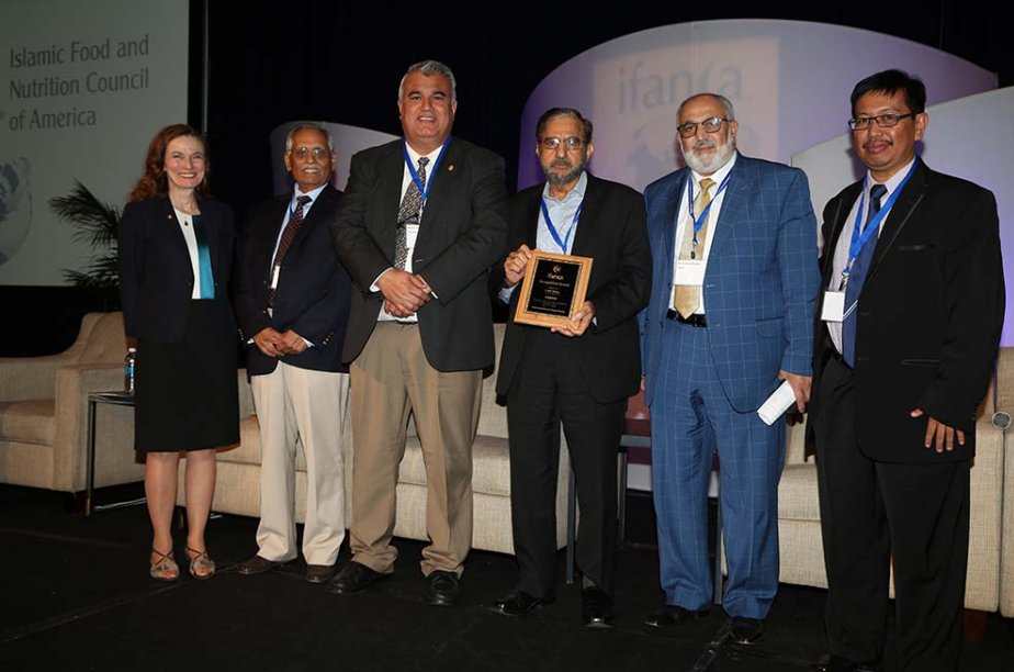 Mary Anne Jackson with IFANCA leaders holding a plaque at the 2017 International Halal Food Conference in Chicago